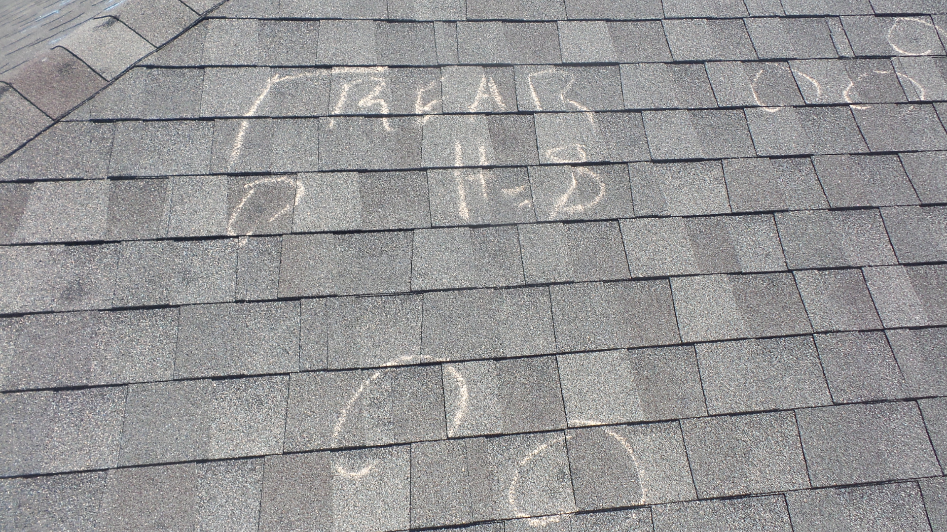 Storm damage repair inspection showing marked hail damage on asphalt shingles